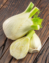 Florence fennel bulbs on aged wood background.