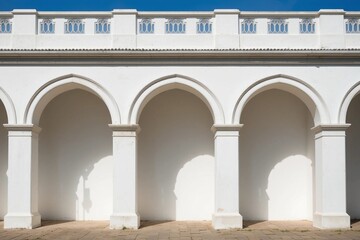 Fototapeta premium White Arched Building Exterior with Columns and Clear Blue Sky Architectural Design