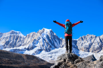 Obraz premium Backpacking woman hiking on high altitude mountain top