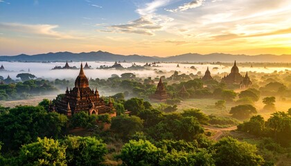 Ancient Buddhist stupas rise from a misty, verdant landscape at sunrise, showcasing a serene and historic panorama.