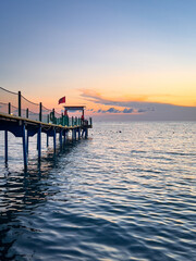 Obraz premium Sunset pier with lifeguard post over tranquil sea