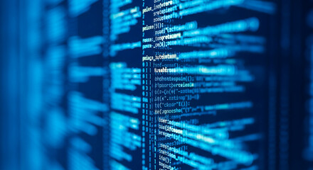 Blurred image of blue computer code on screen, showcasing digital technology and programming concepts