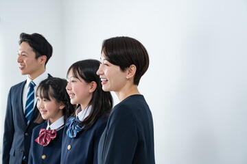 スーツを着た男女と制服を着た女の子二人