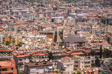 Aerial view of a city with many buildings and red roofs, showcasing the dense urban landscape....
