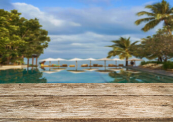 Fototapeta premium Wooden table top on the beach or sea. swimming pool Party on the beach sunshine time concept.For montage product display or design key visual layout.View of copy space.