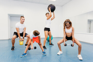 Active family training together in fitness gym
