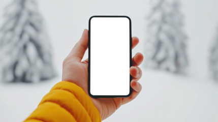 Hand holding smartphone with empty screen in snowy winter forest. Digital mockup for app and mobile design.