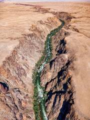 Stunning aerial vertical view of a river winding through a deep canyon