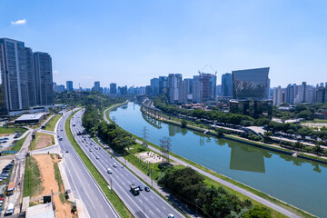 Obraz premium Aerial view of Marginal Pinheiros alongside Rio Pinheiros in Sao Paulo showcasing the urban landscape. Residential and commercial buildings in Sao Paulo