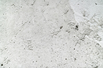 Closeup of rough textured white concrete surface ideal for construction, background, or design projects. Suitable for textures and backgrounds.