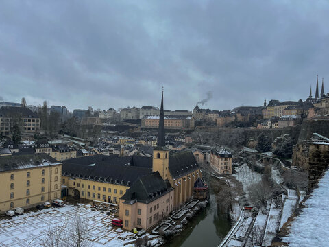 Panoramic view of the Grund district covered in snow during winter, featuring the Neum&uuml;nster Abbey next to the Alzette River. Luxembourg