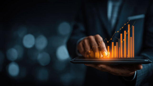 Businessman analyzing sales data and growth charts on tablet for business and financial strategy