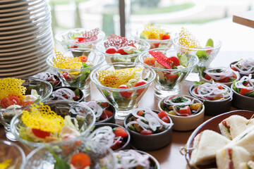 Colorful catering display with fresh salads and triangle sandwiches