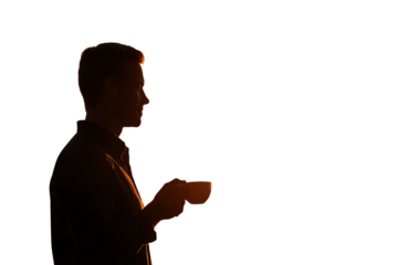 Silhouette of a man holding a cup, enjoying a quiet moment, backlit by warm sunset light.