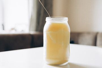 A glass jar filled with creamy yogurt, captured in soft natural light, conveying a fresh and healthy vibe.