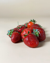 scattered strawberries on beige background closeup