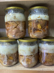 homemade pork stew in jars on display