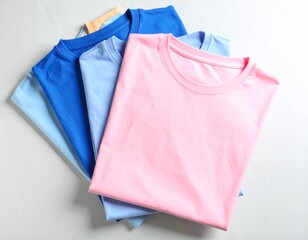 Stack of Folded Plain Colorful T-Shirts on Wooden Background &ndash; Apparel Mockup and Minimalist Fashion Template