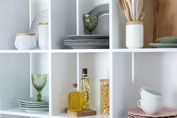 Shelving unit with different dishware, glasses and other kitchen utensils indoors