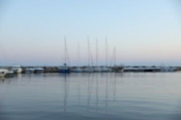 Obraz premium Moored boats in sea port at sunset, blurred view
