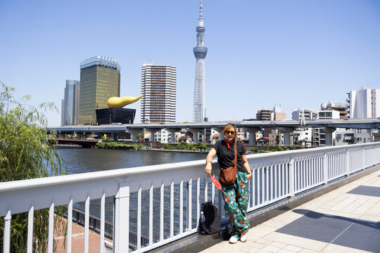 Travelers thai women people travel visit take photo with view landscape cityscape of Taito city and Tokyo Skytree on bridge building crossing sumida river at Asakusa on July 21, 2025 in Tokyo, Japan