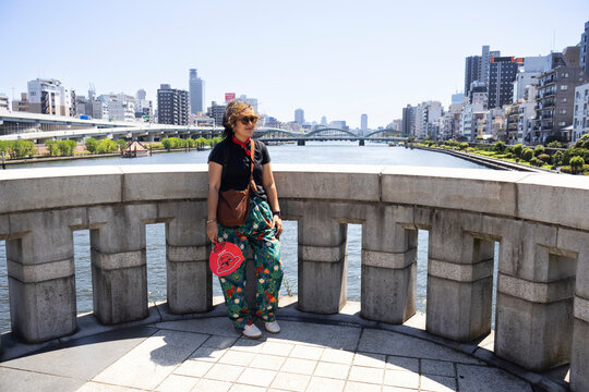 Travelers thai women people travel visit take photo with view landscape cityscape of Taito city and Tokyo Skytree on bridge building crossing sumida river at Asakusa on July 21, 2025 in Tokyo, Japan