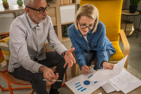 Mature senior couple husband and wife work together form home - Powered by Adobe