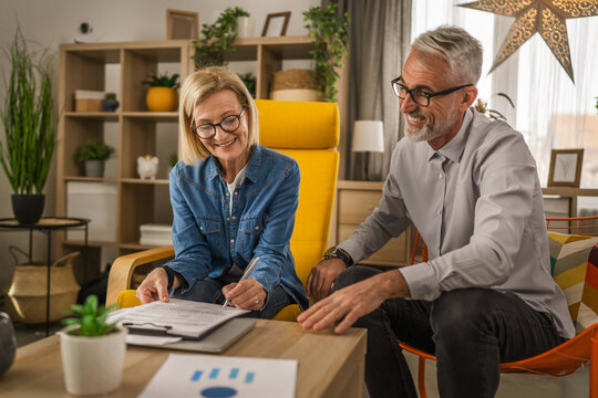 Mature senior woman sign insurance,contract or invoice at home