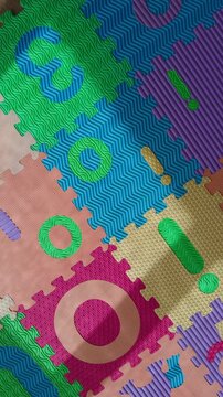 Top view spin shot of a vibrant foam floor mat featuring interlocking puzzle pieces with letters and numbers perfect for kids playgrounds or indoor play areas
