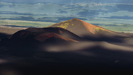 Majestic volcanic landscape showcasing rugged mountains with vibrant green and reddish hues,...