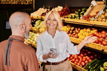 Salesperson guides customer in selecting fresh organic produce at local grocery store