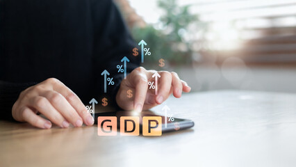 Close-up hand using smartphone with GDP growth icons, arrows, and percent symbols. Concept of economic data, financial analysis, and market trends.