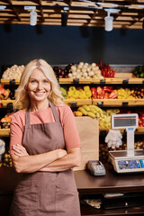Blonde saleswoman assists customers in vibrant organic grocery store