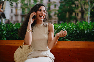 Happy woman talks on phone, gesturing with hand, deeply engaged in emotional voice call, showing...