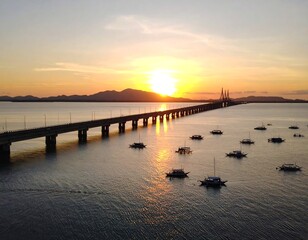 Golden sunset casting its glow over a bridge, boats and water creating a serene tropical scene