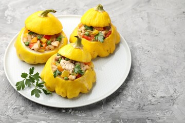 Tasty stuffed pattypan squashes on grey textured table, closeup