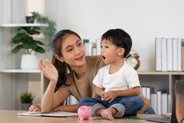 Fototapeta premium Money Management. Child excitedly learning about savings with mother.