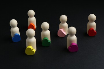 Tolerance concept. Human figures and colorful hearts on black background, closeup