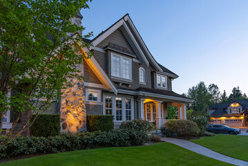 Two story stucco luxury house with nice Spring blossom landscape at night in Vancouver, Canada, North America. May 2025.