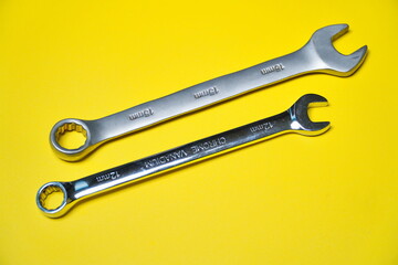 2 combination wrenches in the photo with isolated yellow background