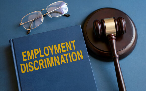 Legal concept of employment discrimination and workplace justice, with a law book, judge's gavel, and glasses on a desk. - Powered by Adobe
