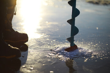 Ice ax - ice screws on winter fishing on the ice caves. Ice is very clean and beautiful. The Lake Baikal.