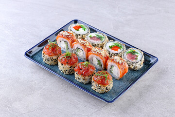 Elegant Sushi Roll Assortment with Salmon, Tuna, Sesame Crust, and Fresh Garnishes