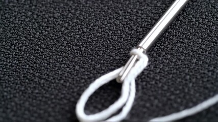 Detailed macro shot of a silver tuning fork vibrating against a black background. Instrument detail