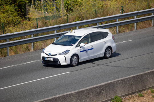 White toyota prius taxi driving on highway in summer