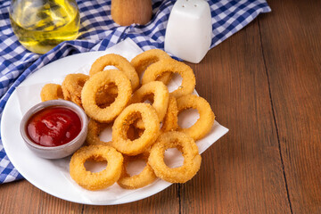 Golden onion rings with ketchup sauce, airfryer cooked tasty onion ring snacks on white wooden table copy space