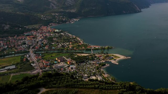 High angle panoramic view of Torbole on Lake Garda, northern Italy town, beaches, and shoreline against mountain slopes
