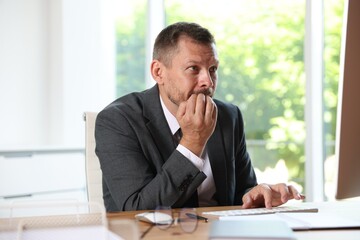 Naklejka premium Businessman suffering from panic attack at workplace in office