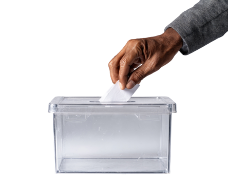 Hand inserting a ballot into a clear plastic voting box