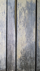 Weathered gray wooden texture with vertical grain and peeling yellow paint